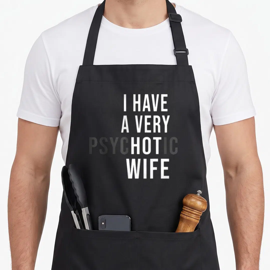 Hot wife apron - Stacked white and grey text reading I HAVE A VERY PSYCHOTIC WIFE on grey background — shown on a black cotton canvas apron against a white background