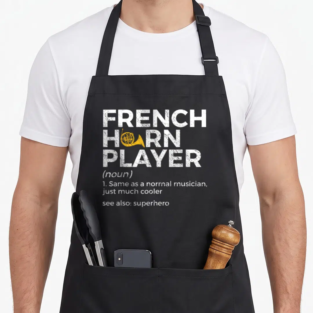 Player french apron - Distressed white text reading French Horn Player with yellow horn graphic inside the O — shown on a black cotton canvas apron against a white background