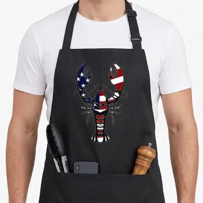 Crayfish crawfish apron - Cartoon lobster filled with red white blue USA flag pattern — shown on a black cotton canvas apron against a white background