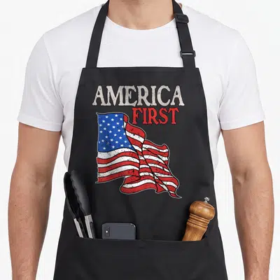 Patriot memorial american flag apron - Waving USA flag with distressed AMERICA FIRST text in red white and blue — shown on a black cotton canvas apron against a white background