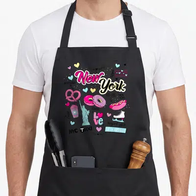 Funny illustration new york apron - Cartoon New York collage with pretzels, hot dogs, Statue of Liberty, and text — shown on a black cotton canvas apron against a white background