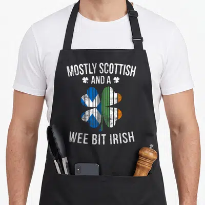 Scottish irish aprons - Distressed shamrock split into blue and green orange flags with white text — shown on a black cotton canvas apron against a white background
