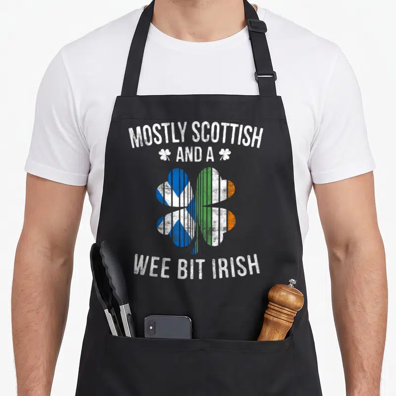 Scottish irish aprons - Distressed shamrock split into blue and green orange flags with white text — shown on a black cotton canvas apron against a white background