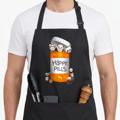 Pill best ferret apron - Orange pill bottle with Häppy PILLS text and cartoon ferrets peeking out and gathered at base — shown on a black cotton canvas apron against a white background