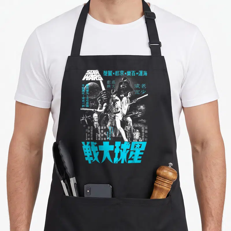 Kanji hope apron - Star Wars character collage with distressed Chinese text in blue and white — shown on a black cotton canvas apron against a white background