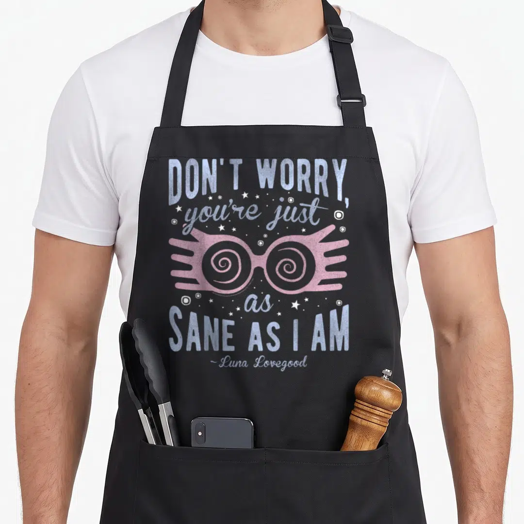 Luna a's aprons - Pink spectacles with spiral lenses surrounded by blue text and white stars — shown on a black cotton canvas apron against a white background