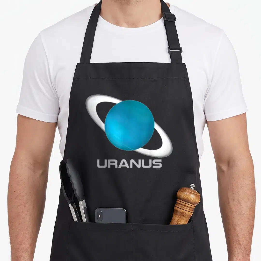 Uranus quran apron - Realistic blue planet with white ring and URANUS text below — shown on a black cotton canvas apron against a white background