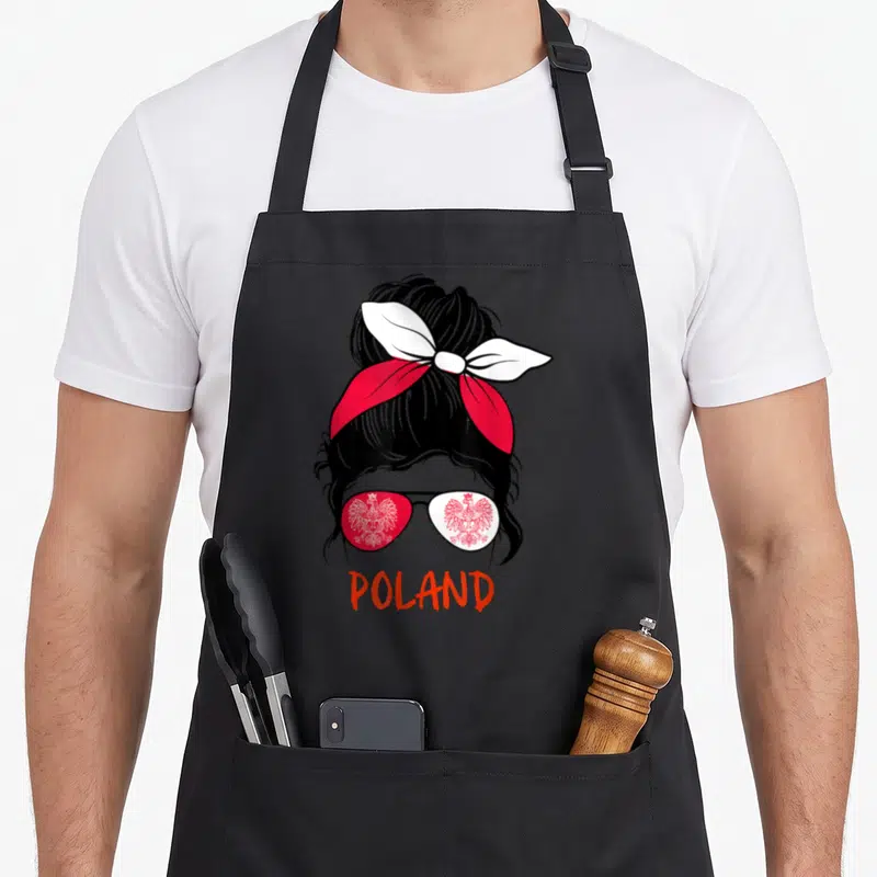 Messy polish aprons - Cartoon woman bun red white sunglasses eagle print POLAND text — shown on a black cotton canvas apron against a white background