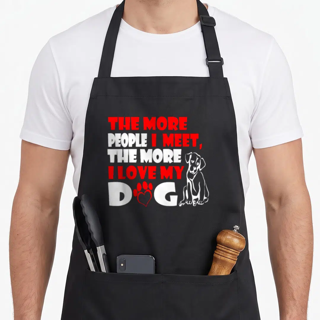 Retro meet dog apron - Stacked red and white text next to a sitting dog and red paw print containing a heart outline — shown on a black cotton canvas apron against a white background
