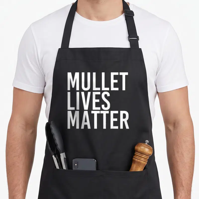 Mullet hillbilly apron - White stacked text reading MULLET LIVES MATTER on grey background — shown on a black cotton canvas apron against a white background
