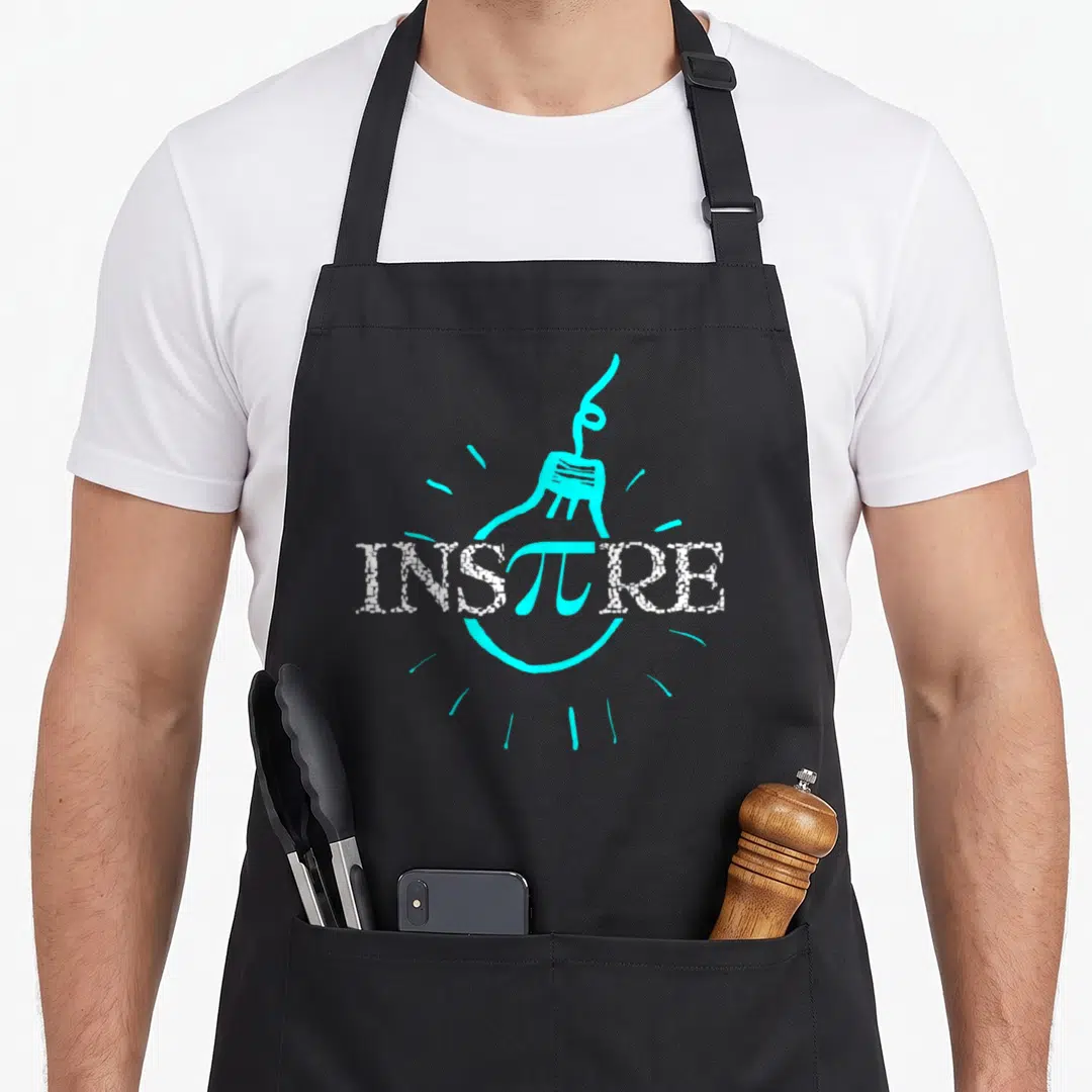 Inspire science apron - Cyan light bulb outline with INSπRE text and pi symbol in white and cyan — shown on a black cotton canvas apron against a white background