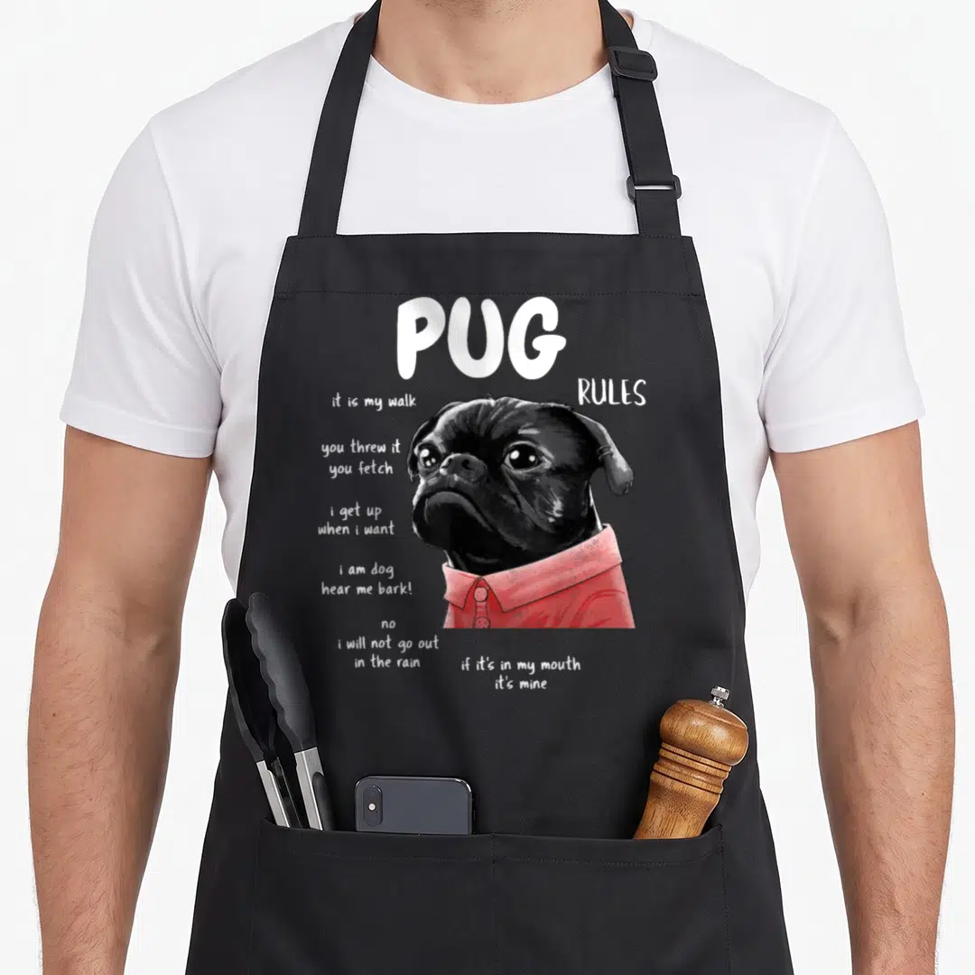Kawaii dog rules apron - Realistic black pug in red shirt with white text listing humorous dog rules — shown on a black cotton canvas apron against a white background