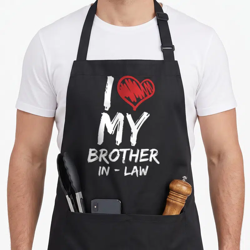 Vintage brother in law apron - White I MY BROTHER IN-LAW text next to a red scribbled heart — shown on a black cotton canvas apron against a white background