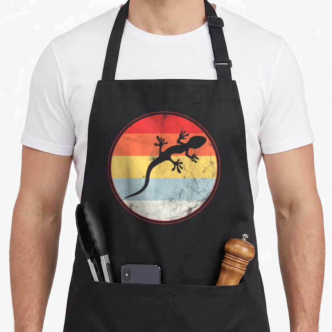 Lizard hobby apron - Grey lizard silhouette on distressed red orange yellow blue white and grey horizontal stripes — shown on a black cotton canvas apron against a white background