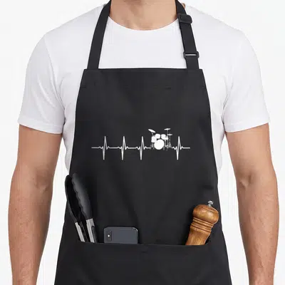 Heartbeat drum apron - White drum kit silhouette resting on a horizontal heartbeat pulse line — shown on a black cotton canvas apron against a white background