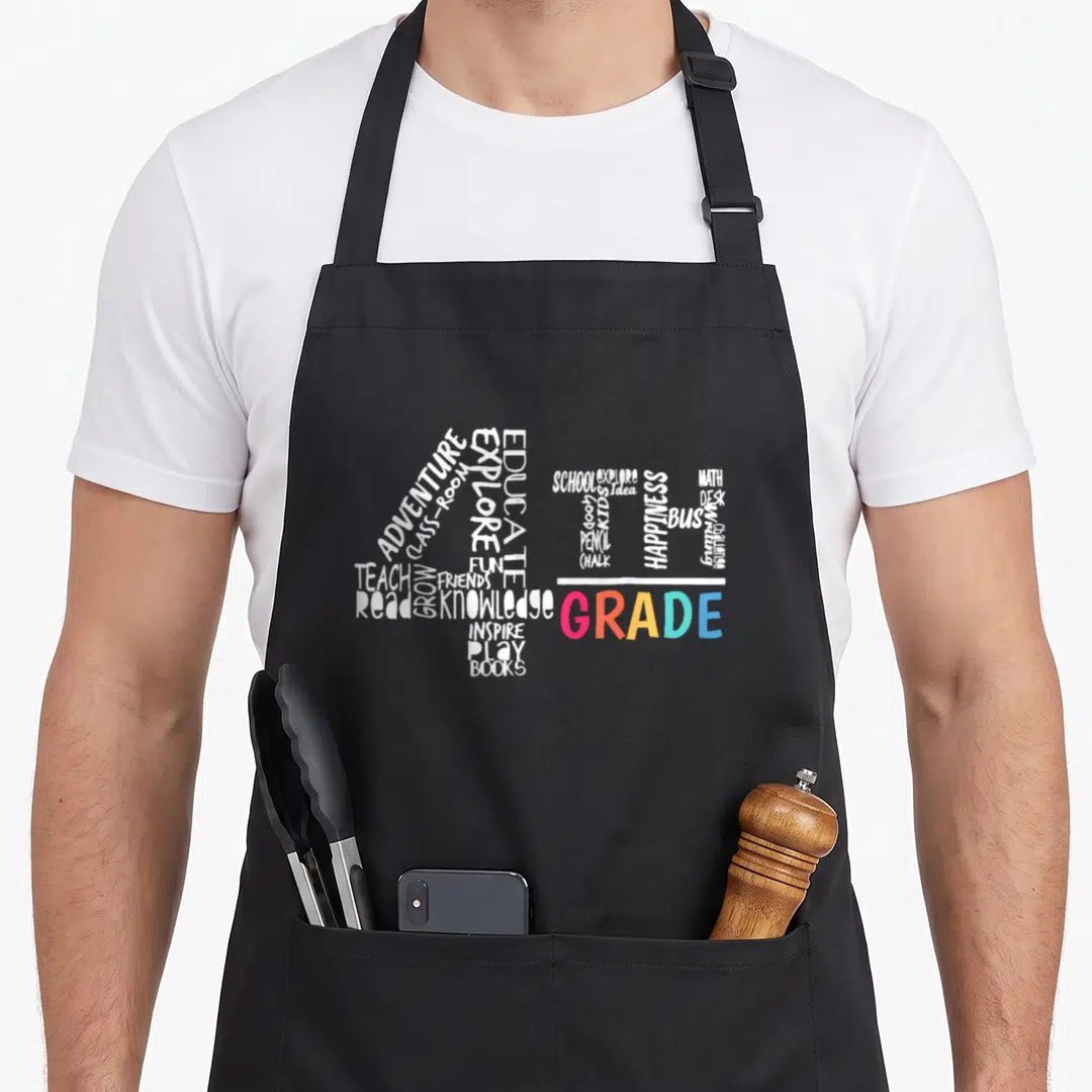 Fourth student aprons - 4TH GRADE formed by white and multicolored words like math, books, and chalk — shown on a black cotton canvas apron against a white background