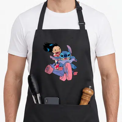 Adventure bike apron - Lilo and Stitch riding a purple and pink go-kart with excited expressions in a cartoon style — shown on a black cotton canvas apron against a white background