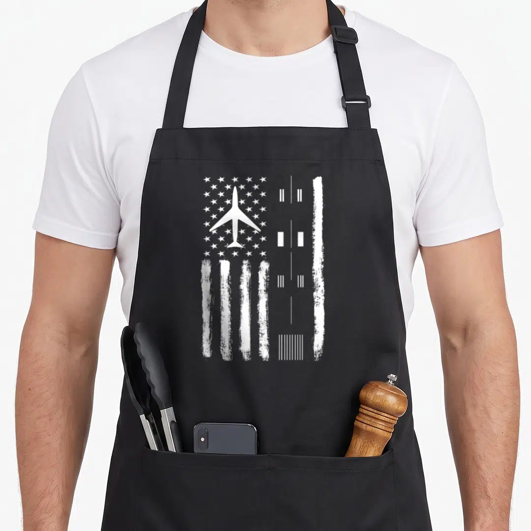 Flag air traffic controller apron - White airplane silhouette over stars and stripes next to a runway diagram on black — shown on a black cotton canvas apron against a white background