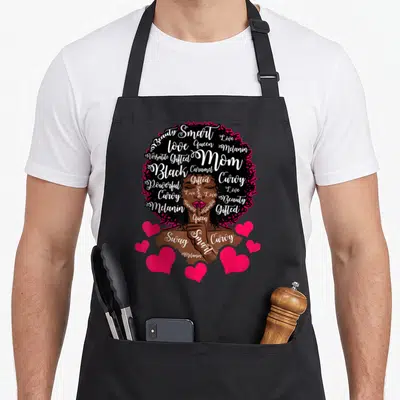 African mother's day aprons - White script words forming a woman's silhouette with pink hearts on black — shown on a black cotton canvas apron against a white background