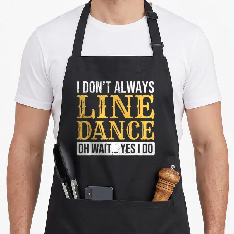 Dancer dance line apron - Stacked white and yellow text reading I DON'T ALWAYS LINE DANCE OH WAIT YES I DO inside — shown on a black cotton canvas apron against a white background