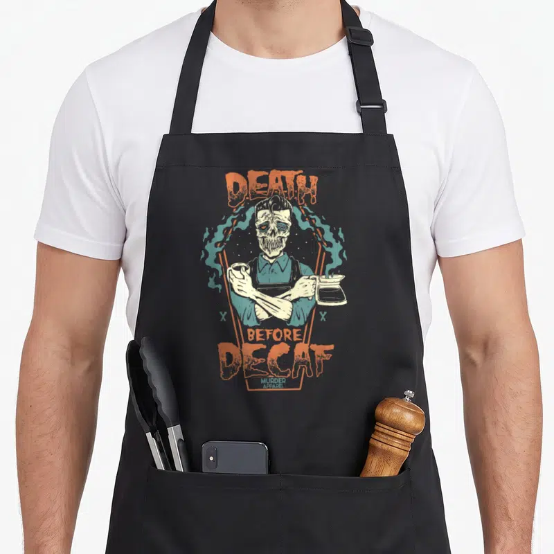 Addict coffee apron - Skeleton barista holding cup and pot with DEATH BEFORE DECAF text in orange and teal smoke — shown on a black cotton canvas apron against a white background