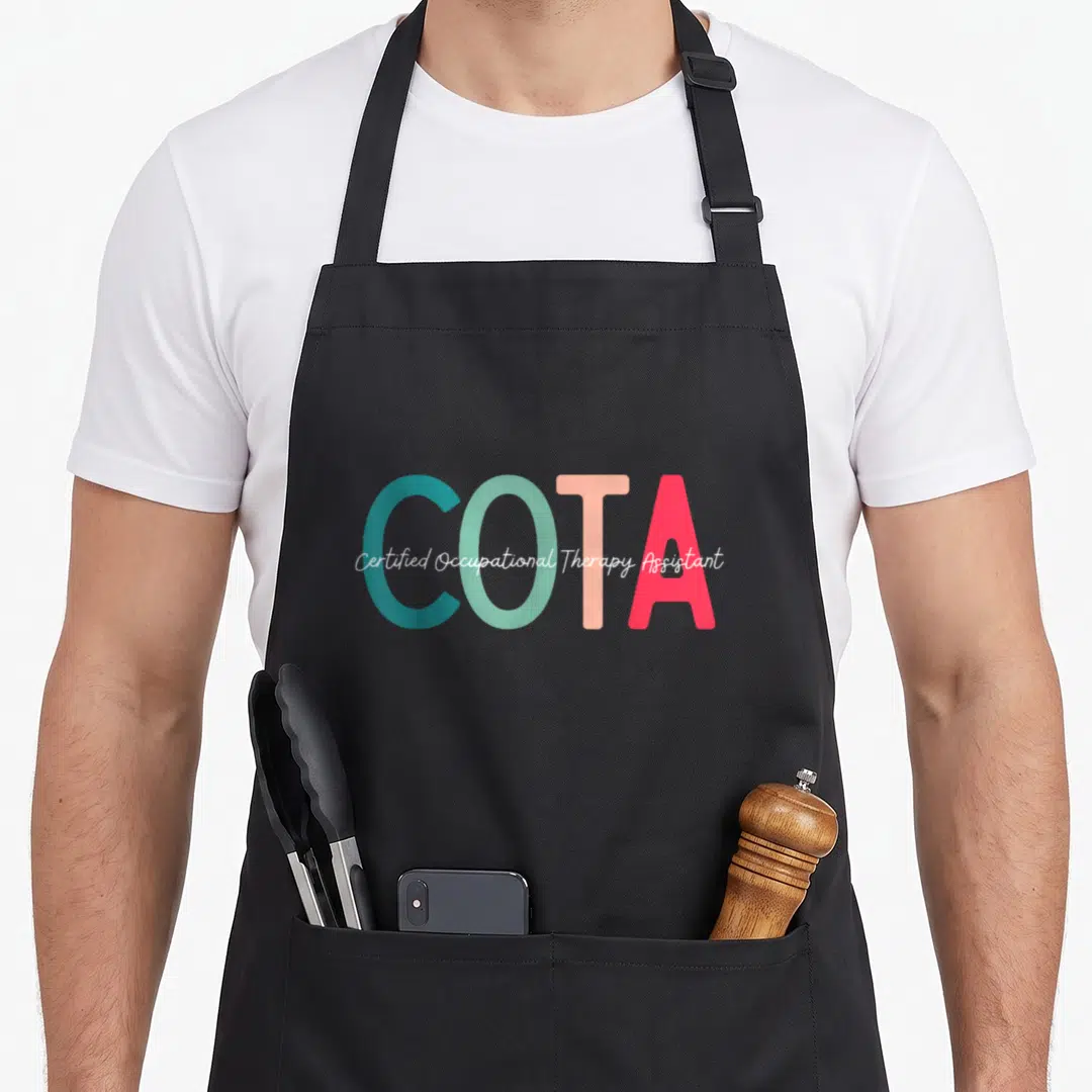 Certified my therapy apron - COTA in teal mint peach pink with white script text — shown on a black cotton canvas apron against a white background