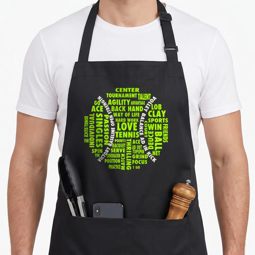 Tennis voice actor apron - Lime green and white tennis terms forming a ball shape via typography — shown on a black cotton canvas apron against a white background