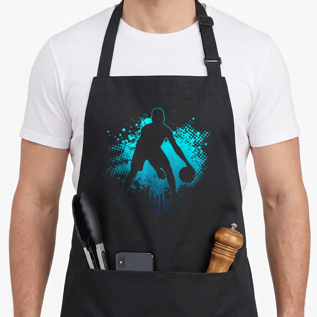 Bball basketball player apron - Cyan and blue silhouette of a basketball player dribbling with halftone splatter — shown on a black cotton canvas apron against a white background