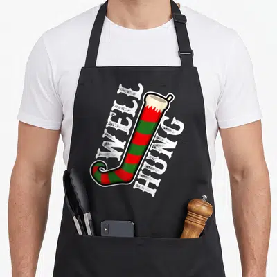 Well christmas elf apron - Striped red green stocking with well hung text in cartoon style — shown on a black cotton canvas apron against a white background