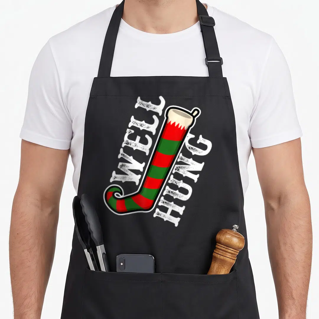 Well christmas elf apron - Striped red green stocking with well hung text in cartoon style — shown on a black cotton canvas apron against a white background