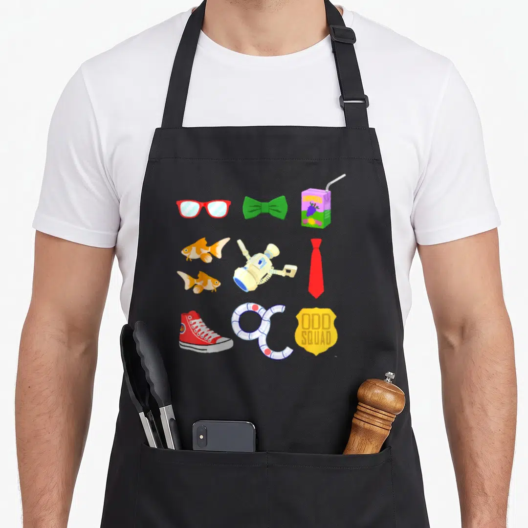 Odd from squad apron - Odd Squad badge, red glasses, green bow tie, orange fish, and juice box in cartoon art — shown on a black cotton canvas apron against a white background