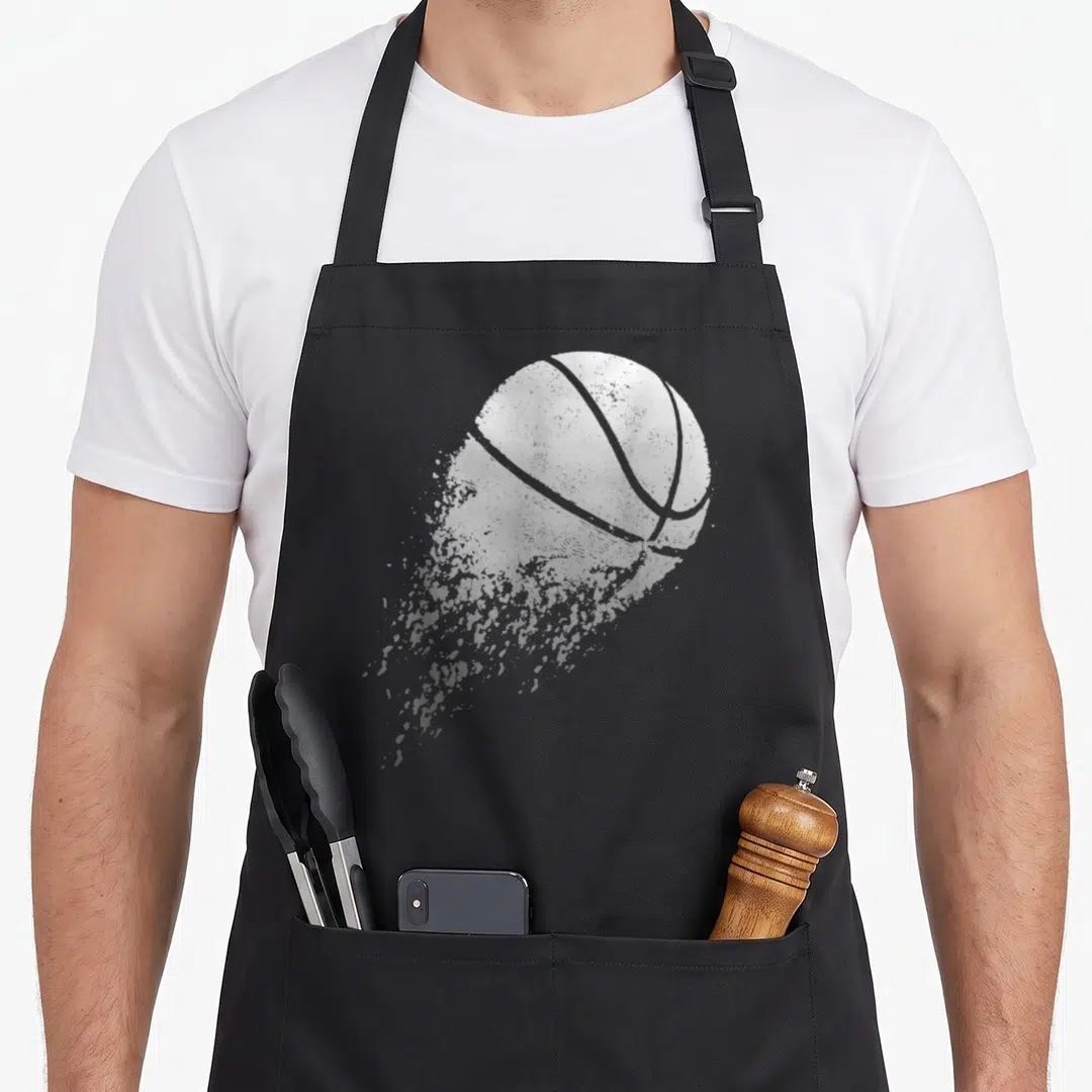 Player sports fan apron - Distressed white basketball with grey splatter trail on grey background — shown on a black cotton canvas apron against a white background