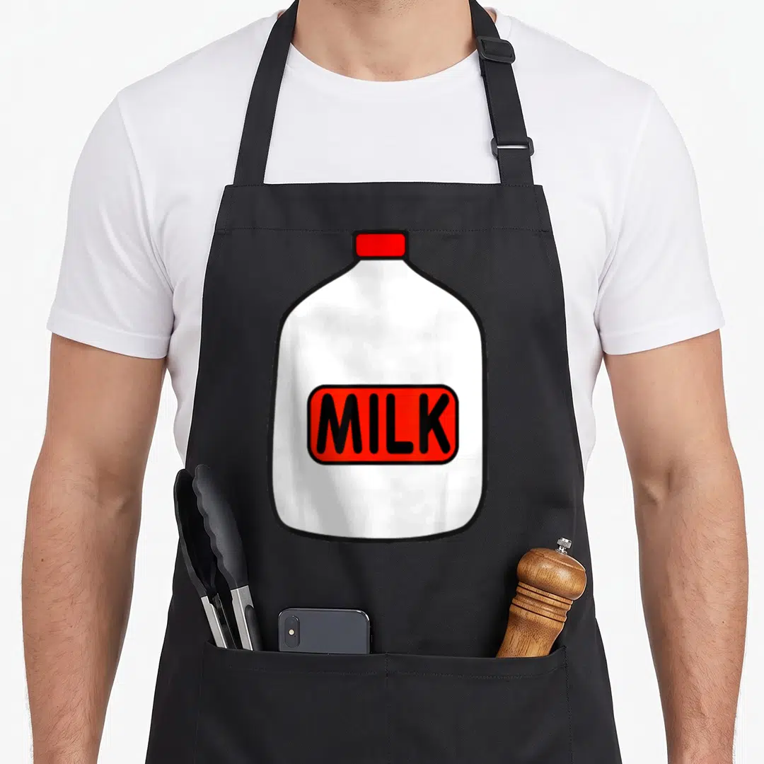 Gallon milk aprons - White milk jug with red cap and red label reading MILK in black cartoon style — shown on a black cotton canvas apron against a white background