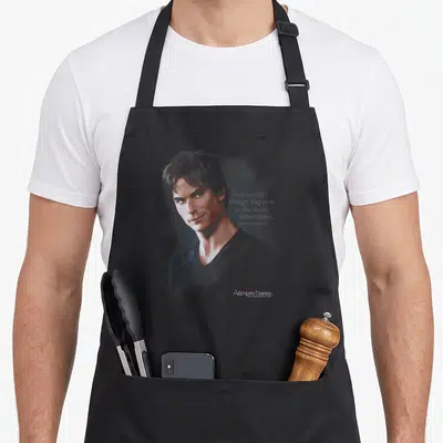 Vampire tv apron - Realistic man portrait with stacked text Interesting things happen in the dark Sometimes Damon — shown on a black cotton canvas apron against a white background