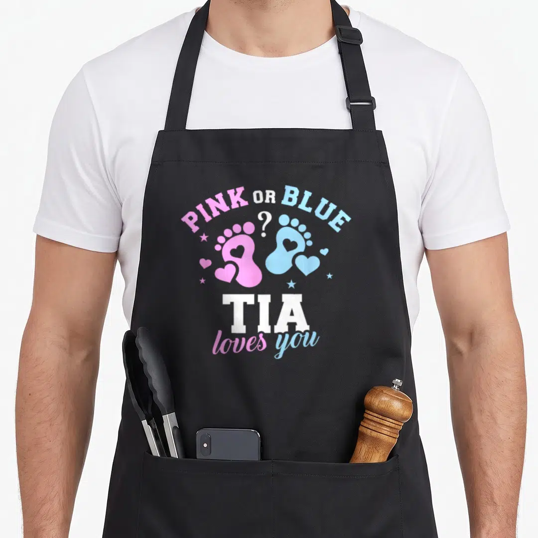Tia gender reveal apron - Pink and blue baby footprints with PINK OR BLUE text and TIA loves you — shown on a black cotton canvas apron against a white background