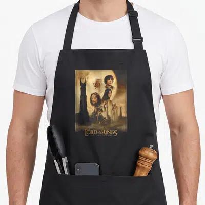 Poster ring apron - Montage of Gandalf and other characters with Two Towers text in brown and blue — shown on a black cotton canvas apron against a white background