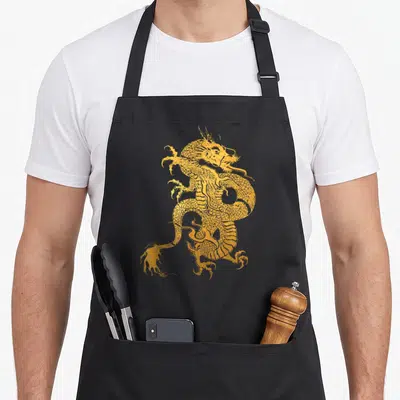 Dragon traditional chinese apron - Golden line-art dragon print with scales and claws centered on grey background — shown on a black cotton canvas apron against a white background