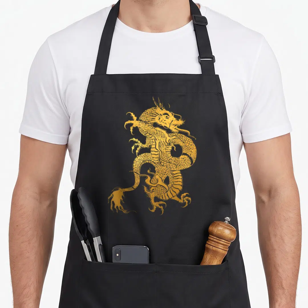 Dragon traditional chinese apron - Golden line-art dragon print with scales and claws centered on grey background — shown on a black cotton canvas apron against a white background