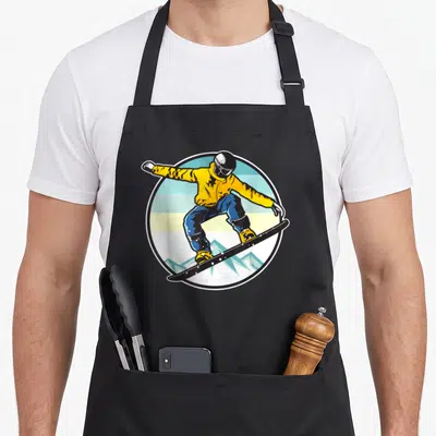 Snowboarder boarding apron - Cartoon snowboarder in yellow jacket and blue pants inside a circle with striped — shown on a black cotton canvas apron against a white background