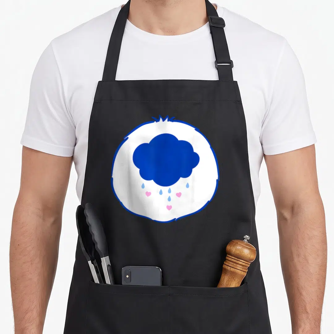 Grumpy halloween apron - Blue cloud with pink hearts and blue raindrops inside white circle with blue border — shown on a black cotton canvas apron against a white background