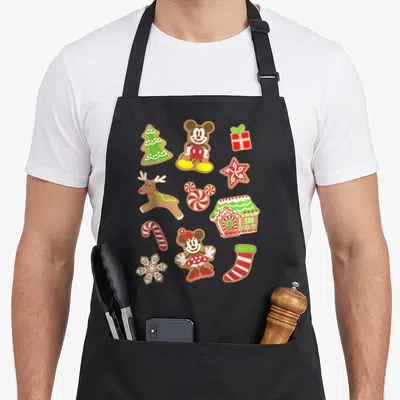 Cooky women's christmas aprons - Cartoon gingerbread Mickey Minnie tree house reindeer candy cane star snowflake — shown on a black cotton canvas apron against a white background