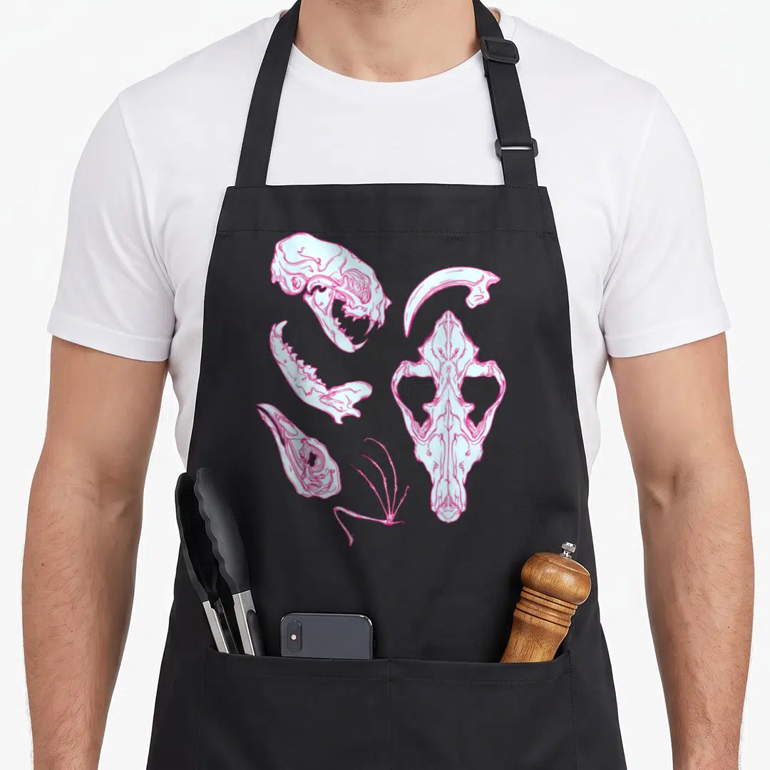 Vulture goth apron - Light blue and pink line art of scattered animal skulls and a claw on a black background — shown on a black cotton canvas apron against a white background