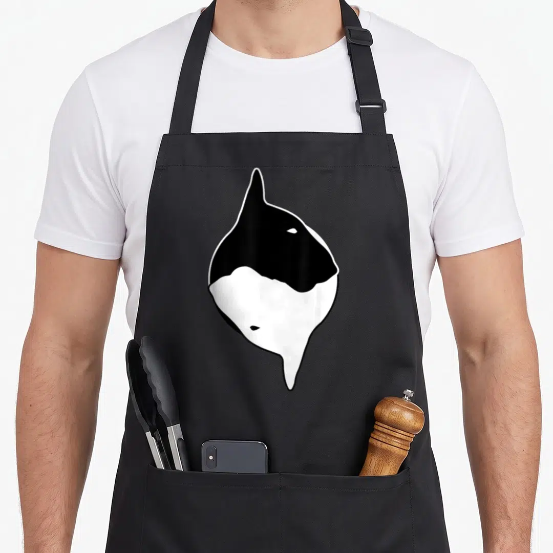 Yin dog dad apron - Stylized black and white orca shape resembling a yin yang symbol — shown on a black cotton canvas apron against a white background