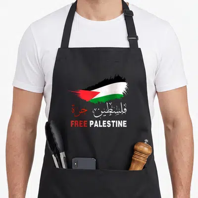 Gaza arabic palestine apron - Brush stroke flag with Arabic script and FREE PALESTINE text in black white green red — shown on a black cotton canvas apron against a white background