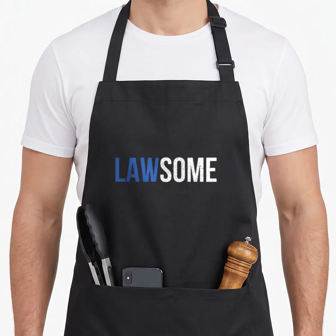 Law exam apron - LAWSOME text in blue and white sans-serif font on grey background — shown on a black cotton canvas apron against a white background