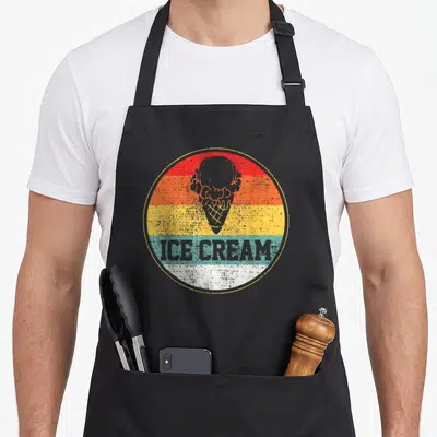 Treat ice cream apron - Retro ice cream cone on red orange yellow teal white stripes with grey text — shown on a black cotton canvas apron against a white background