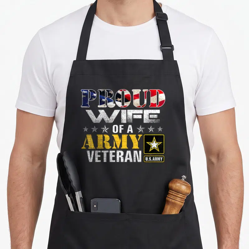 Wife american flag apron - Stacked text PROUD WIFE OF A ARMY VETERAN with flag pattern fill and U.S.Army logo block — shown on a black cotton canvas apron against a white background