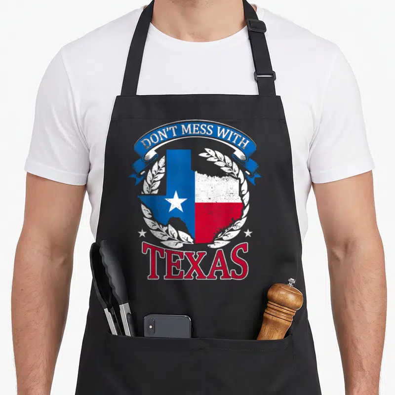 Mess state texas apron - Retro Texas map in blue white and red with laurel wreath and arched text — shown on a black cotton canvas apron against a white background