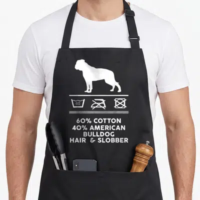 Funny american bulldog apron - White bulldog silhouette above laundry symbols and text 60% cotton 40% american bulldog — shown on a black cotton canvas apron against a white background