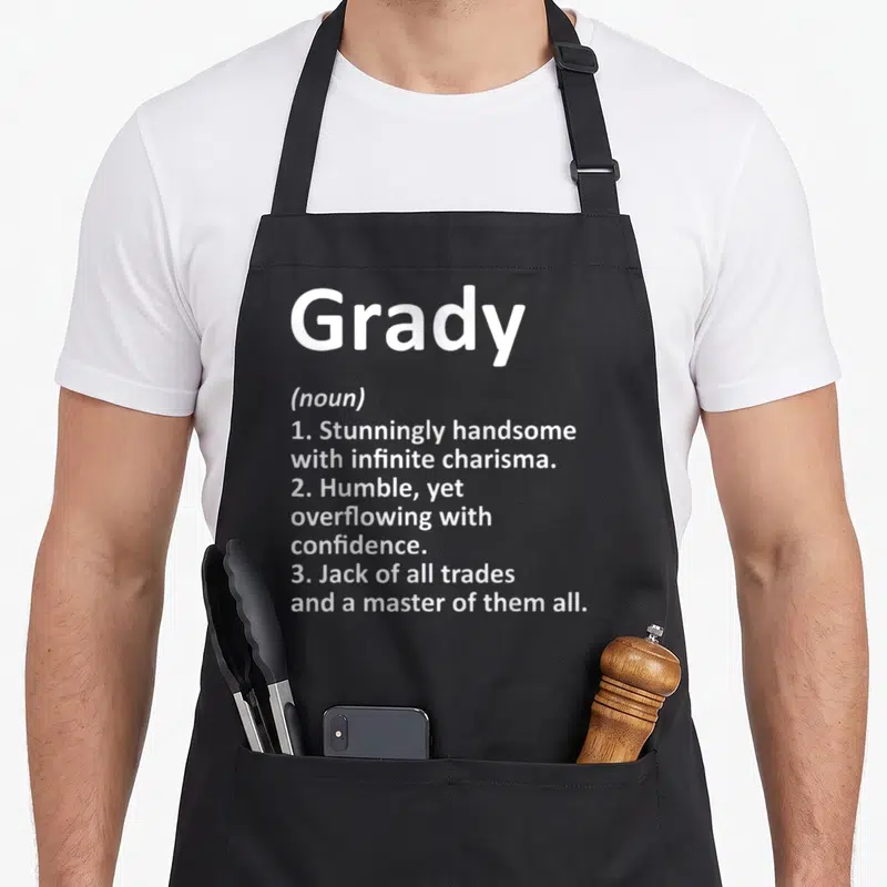 Grady father day aprons - White text defining Grady as handsome, humble, and a jack of all trades on a grey background — shown on a black cotton canvas apron against a white background